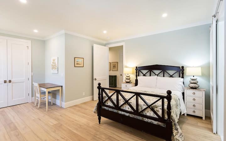Dormitorio tamaño queen con cama tamaño queen, televisión, escritorio y baño adjunto.