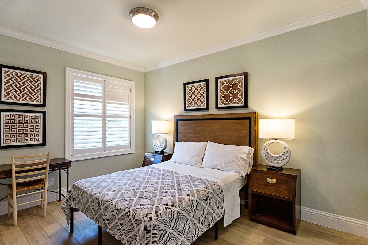 Tercer dormitorio con cama tamaño Queen, TV, escritorio y baño adjunto.