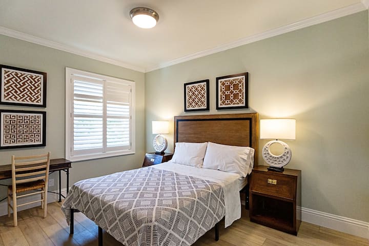 Tercer dormitorio con cama tamaño queen, TV, escritorio y baño adjunto.