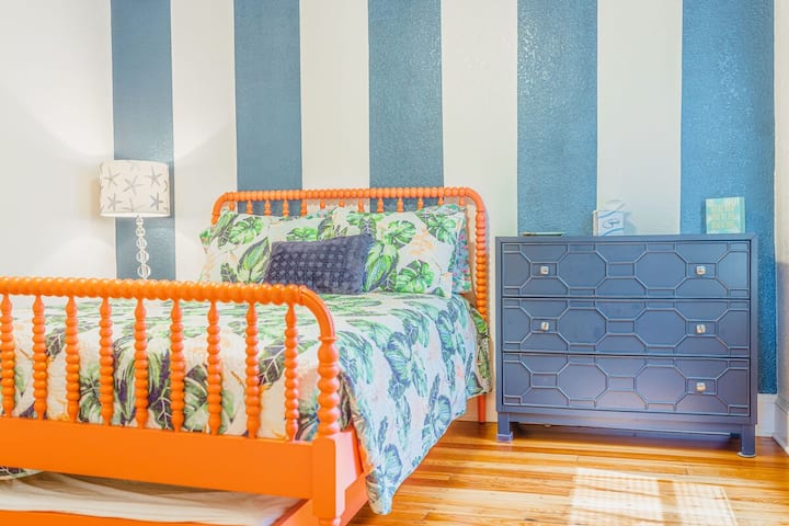 Double bed with a twin trundle that pulls out.  
Step into this lively and inviting bedroom with tropical vibes. The standout feature is the eye-catching coral bed frame with intricate spindles, perfectly complemented by botanical-patterned bedding.