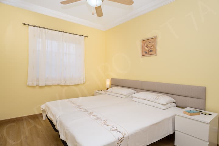 Dhomë gjumi dyshe plot dritë me shtroja të bardha dhe dysheme druri në këtë apartament të pastruar profesionalisht pranë Carvoeiro, Algarve