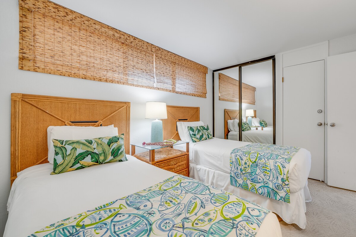 Dormitorio de invitados con cómodas camas individuales y espejo de cuerpo entero.