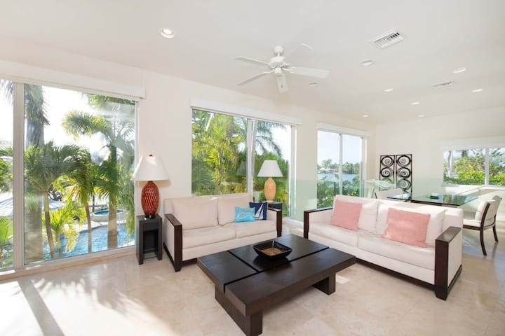 Le salon de la suite avec des fenêtres du sol au plafond et des meubles modernes. 