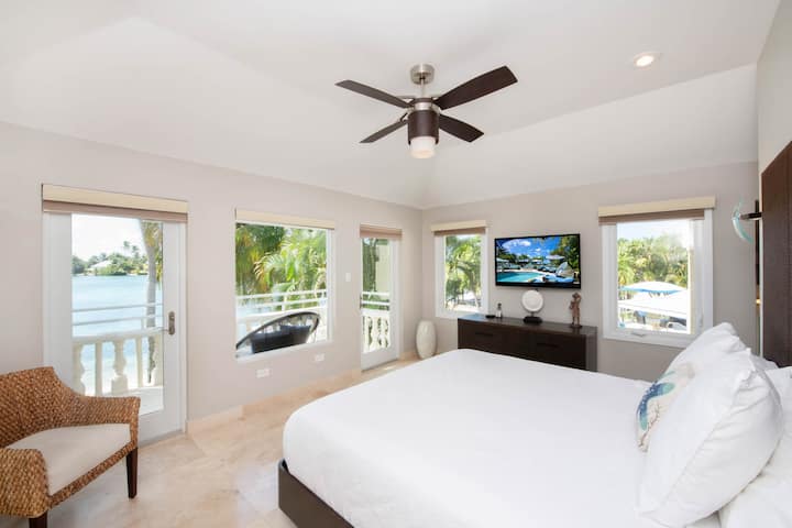 Suite principale avec lit King Size, télévision et accès sans rendez-vous à un balcon privé. 