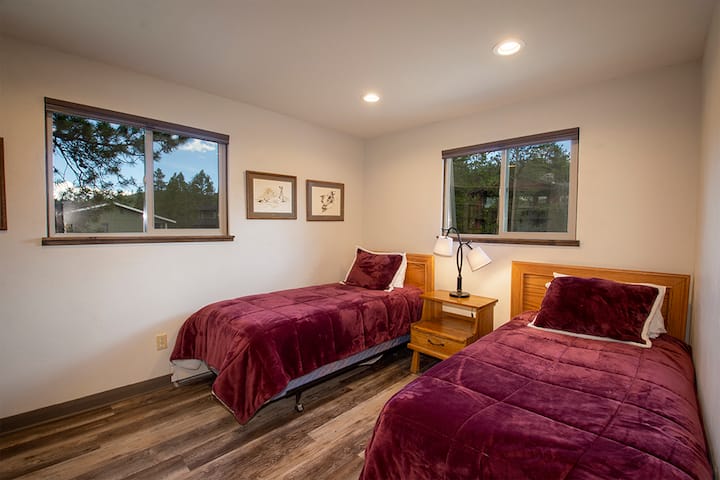 Descansa tranquilamente en tu acogedor dormitorio doble con lujosas sábanas de color burdeos y cálidos detalles de madera que crean el refugio perfecto.