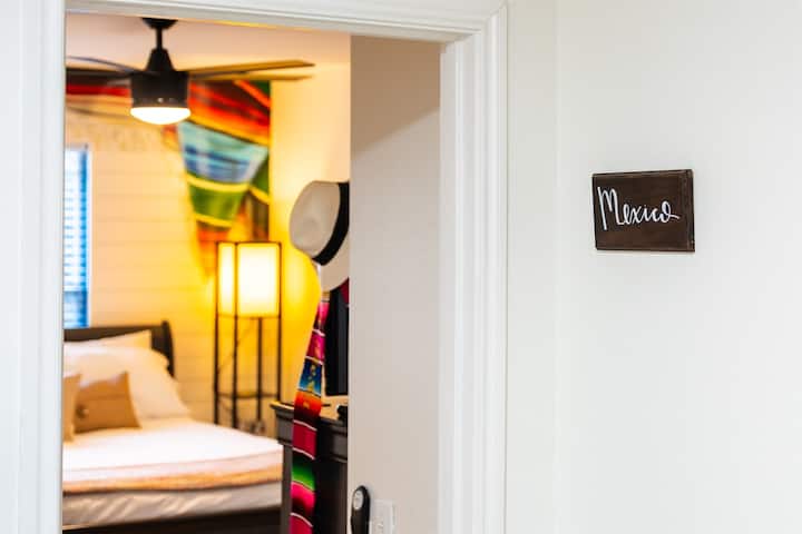 Luxurious queen-sized bed takes center stage amidst a captivating Mexican-themed decor. Discover the perfect blend of comfort and cultural charm in this enchanting space.