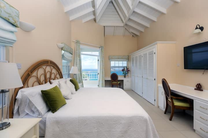 ห้องนอนใหญ่พร้อมทีวีจอแบนห้องน้ำในตัวพร้อมอ่างอาบน้ำและระเบียงส่วนตัว