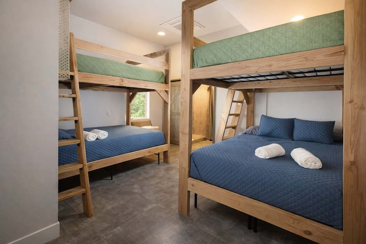 Amplio dormitorio con literas de madera maciza, iluminación suave y un diseño tranquilo y cómodo.