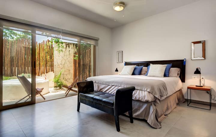 חדר שינה ראשי עם מיטת קינג סייז ומרפסת פרטית עם ג'קוזי