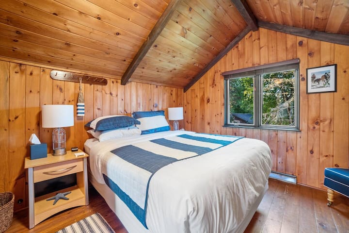 You have arrived up North, the entire upstairs is  covered with knotty pine! Both bedrooms have high ceilings with a fan.  This is a queen bed with a foam topper and luxury linens. 