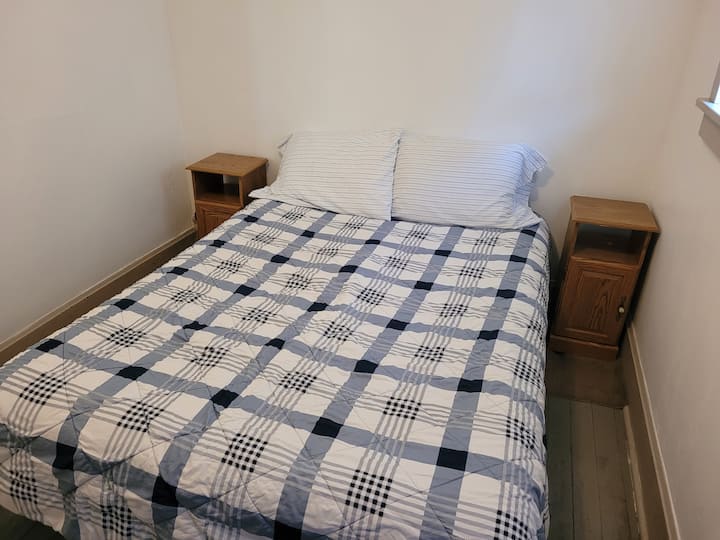 საძინებელი 1 (ძირითადი სართული): აქ არის 152×203 სმ ზომის საწოლი, ტუმბოები, კომოდი, სარკე და კარადა.