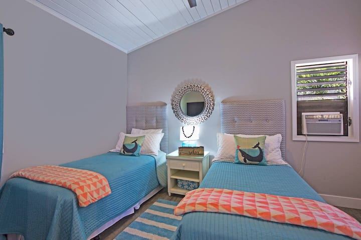 El primer dormitorio tiene dos camas individuales XL, aire acondicionado y ventilador de techo para la comodidad de los huéspedes.