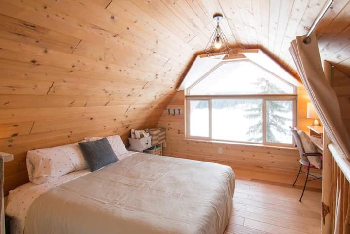 The second bedroom area with queen size bed. 
The "wings" cover the upper window at night, then open, attached by magnets on the ceiling during the day. There are also room darkening roller shades at the bottom.