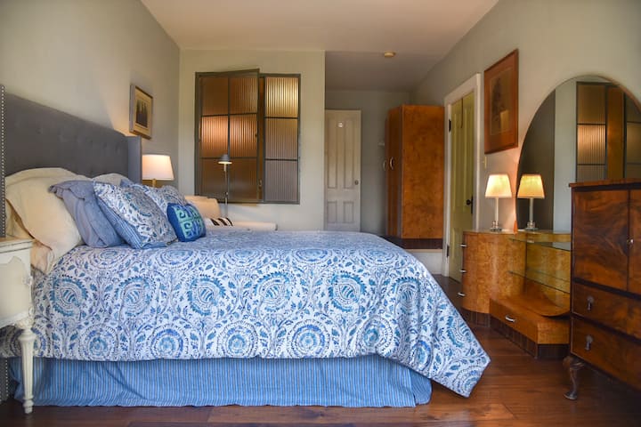 Serene bedroom w/ blue tones, natural light & calm ambiance
