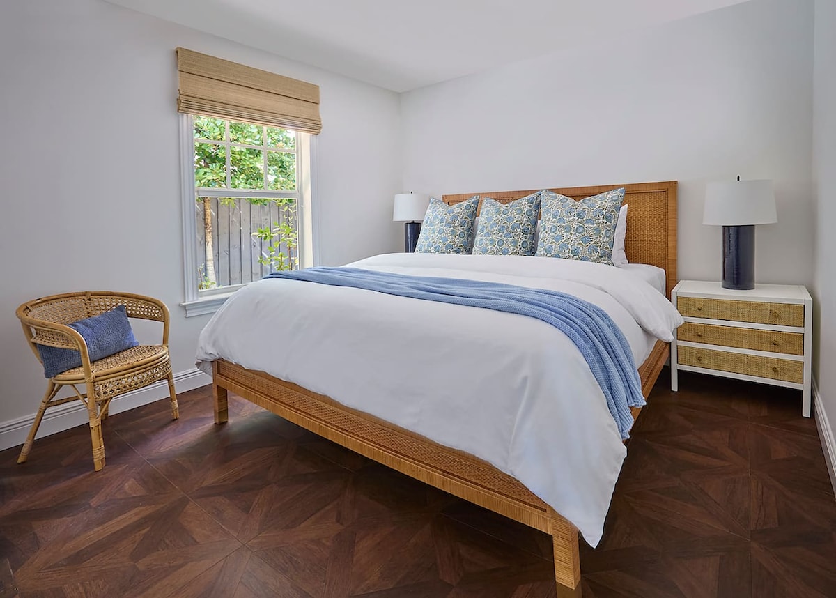 The second bedroom features a Serena & Lily rattan bed dressed in luxurious 800-thread-count linens, an award-winning WinkBed mattress, a TV, and ample storage for your belongings.