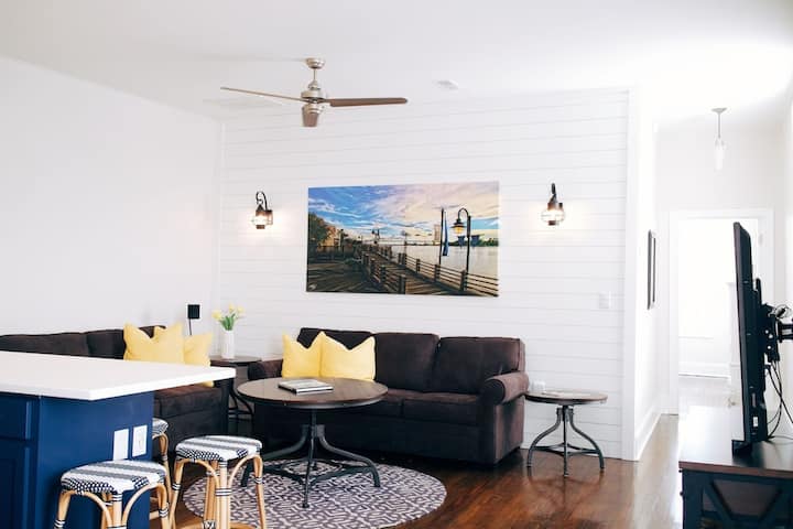 Sala de estar luminosa y de concepto abierto con asientos acogedores y modernos detalles costeros