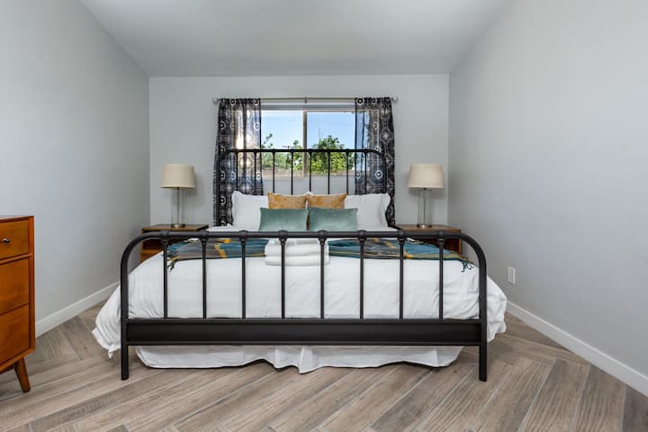 Primary Bedroom with King size bed, large flat-screen TV, and en-suite bathroom.