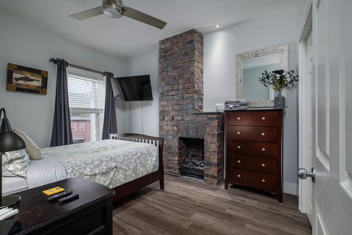 Second level bedroom with beautiful exposed brick fireplace with electric insert. There is a ceiling fan for warm summer nights. 