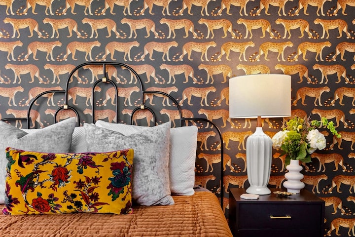 Guest bedroom featuring Cole & Sons leopard wallpaper and Anthropologie furniture with  award winning Bear Mattress and luxury sheets. Of note, this room now has two matching queen beds!