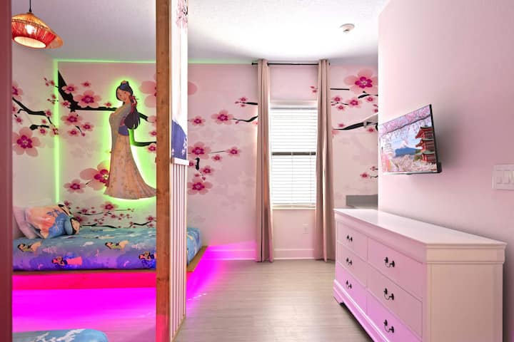 Une fresque murale personnalisée, un éclairage sous le lit et une télévision à écran plat.