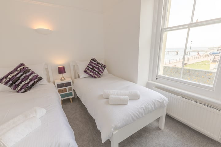 غرفة نوم تضم سريرين صغيرين