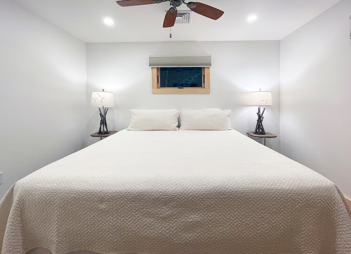 Chumba cha kulala chenye kitanda cha malkia chenye starehe na mwanga laini na rangi zisizo na upendeleo kwa ajili ya ukaaji wa kustarehesha.