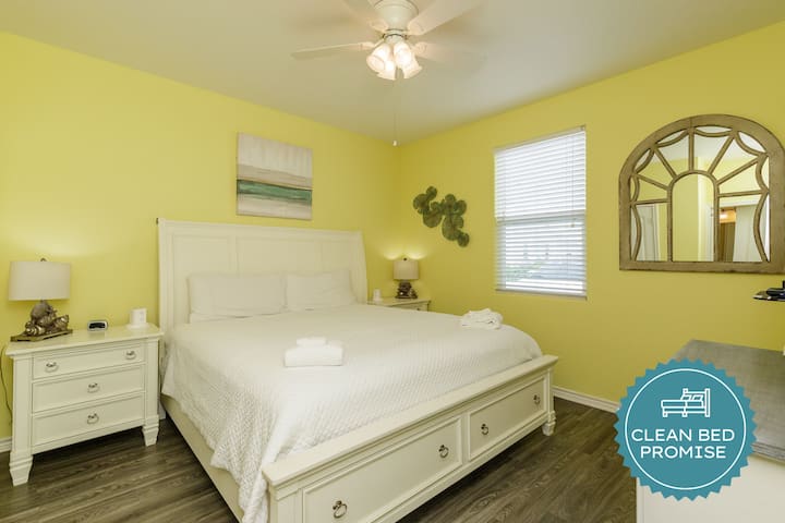 Sink into comfort with crisp white linens and cheerful yellow walls that brighten your mornings. Your peaceful retreat awaits.