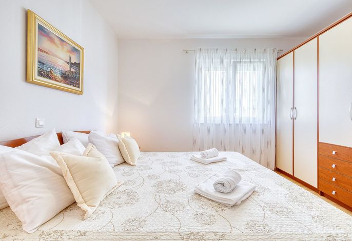 غرفة نوم مشرقة وهادئة مع سرير كبير الحجم مريح وبياضات ناعمة وإضاءة طبيعية دافئة. الكثير من التخزين وحمام داخلي خاص يجعله مثاليًا للإقامات المريحة.