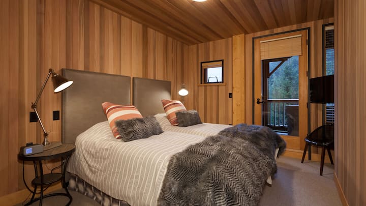 - ห้องนอนสำหรับผู้เข้าพักหุ้มไม้ซีดาร์พร้อมเครื่องนอนเตียงเดี่ยวสองเตียง  
- หน้าต่างขนาดใหญ่และระเบียงที่มองเห็นวิวป่า  
- ออกแบบมาเพื่อการพักผ่อนที่อบอุ่นและค่ำคืนที่สงบบนเทือกเขา  
