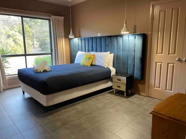 חדר שינה עם נוף אחד מעל החניון הקדמי. מיטת קווין סייז עם סוויטה מלאה וארון אחסון.