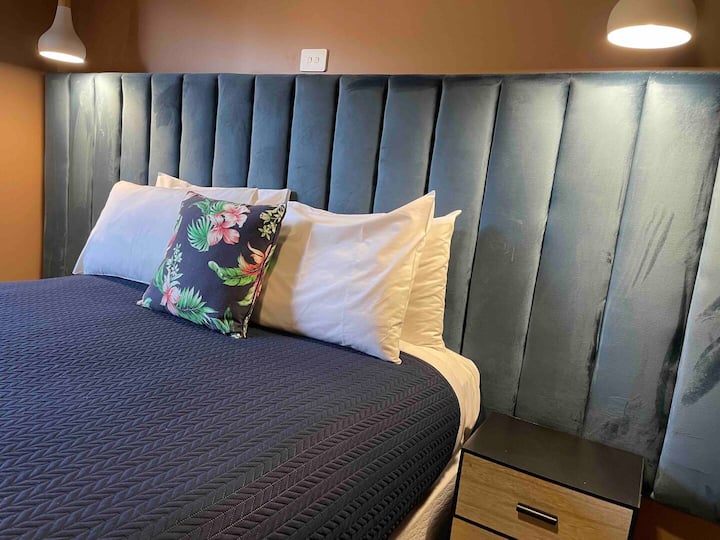 חדר שינה 2 משקיף על הכרם האחורי. מיטת קווין סייז עם סוויטה מלאה וארון אחסון.