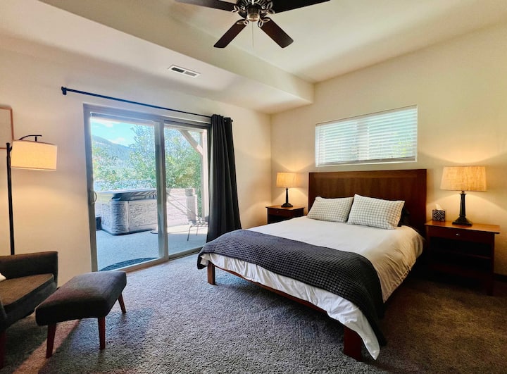 Spavaća soba u prizemlju s bračnim krevetom i staklenim vratima koja vode na terasu i u blizini je masažne kade