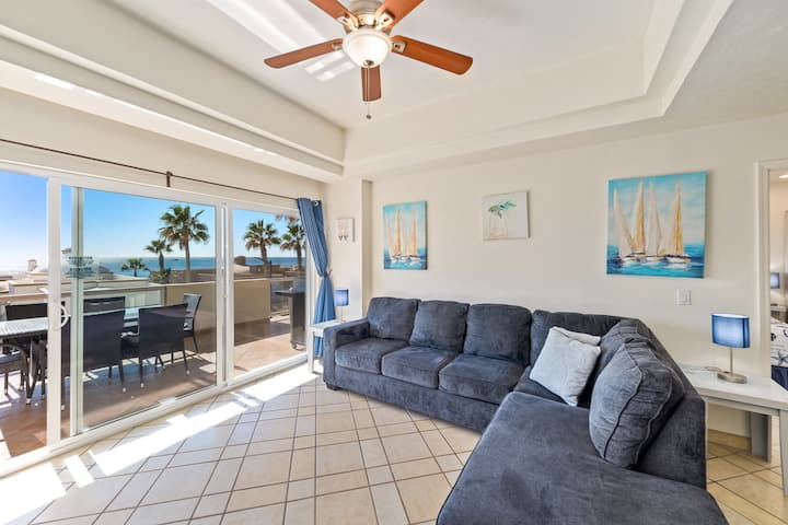 Sala de estar luminosa y espaciosa con acceso al balcón y vistas al mar.