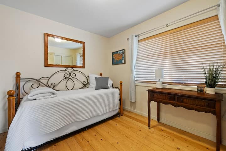 Second bedroom with twin bed and pull-out trundle, French doors, window AC, and cozy charm. Sleeps 2 — perfect for kids or extra guests during a family-friendly Yosemite-area mountain getaway.