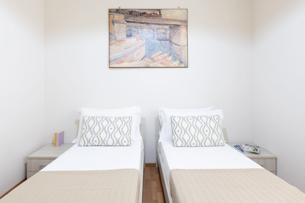 Dva kreveta za jednu osobu s portretom i televizorom