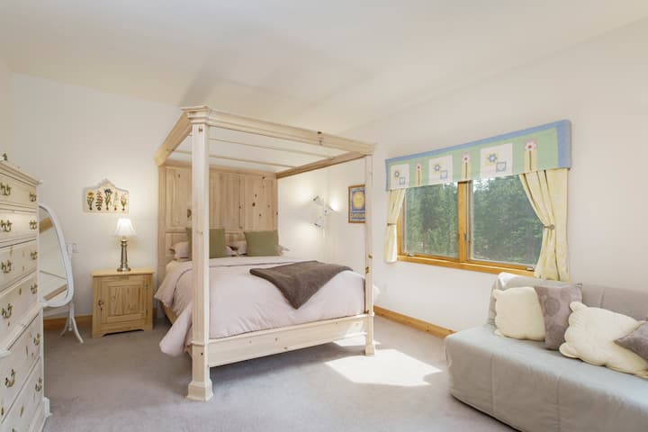 Vista del segundo dormitorio con cama tamaño queen, sofá cama completo, televisión de pantalla plana, cómoda de 5 cajones, vestidor y baño privado.