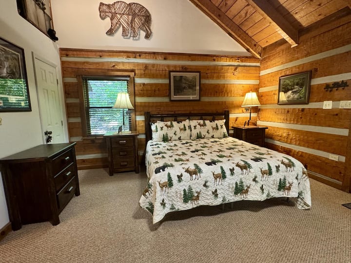 Pohodlná manželská posteľ veľkosti King s nočnými stolíkmi a komodou v spálni.