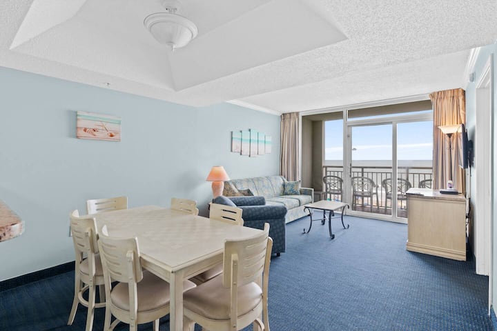 Svijetao i prozračan dnevni boravak i blagovaonica s udobnim garniturom, uređenje u stilu morskog pejzaža i klizna vrata koja se otvaraju na balkon s predivnim pogledom na more.