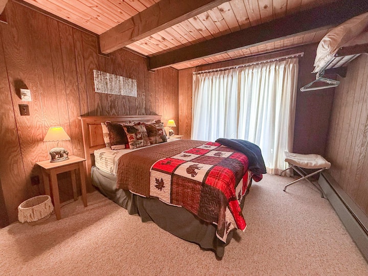 Cozy master bedroom with a queen bed, warm lodge-style décor, and a large sliding door. Perfect for couples or small families visiting Big Powderhorn or the Porcupine Mountains. Pet-friendly and ideal for a relaxing Upper Peninsula getaway
