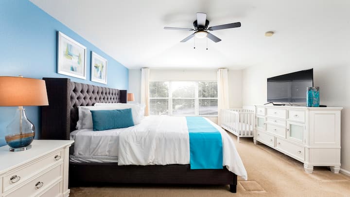 Chumba kikuu cha kulala kwenye ghorofa ya chini kikiwa na kitanda kikubwa aina ya king