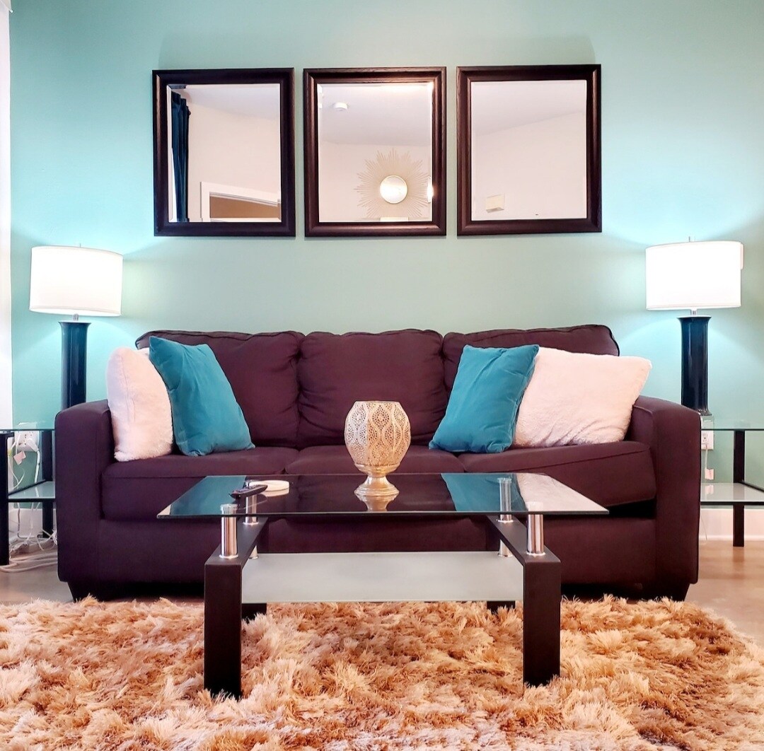 Woonkamer met bank die uitkomt op een queensize slaper, deur naar eigen patio, Smart Roku TV.