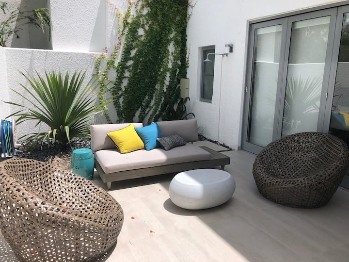 В главном патио есть небольшой культурный сад, диван на открытом воздухе и два.
глубокие ротанговые кресла