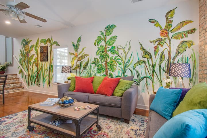 غرفة معيشة في الطابق السفلي مع أريكة كاملة للنوم وجداريات جدارية رائعة في جميع الأنحاء