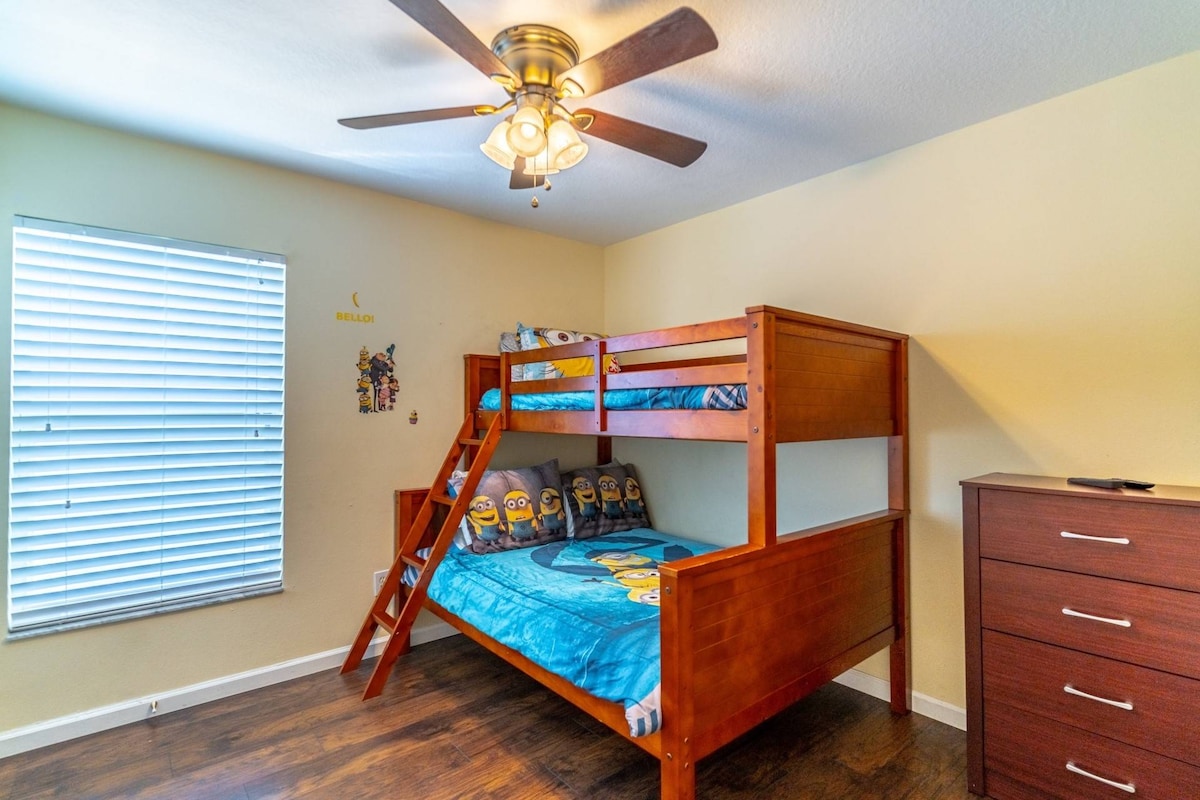 ห้องนอนสองชั้นพร้อมเตียงแฝดเหนือเตียงสองชั้นเต็มรูปแบบและทีวีจอแบน