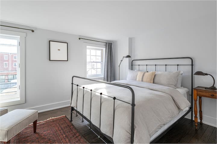 Bedroom #2  - A sunlit bedroom with a sleek iron bedframe and clean, minimalist decor.