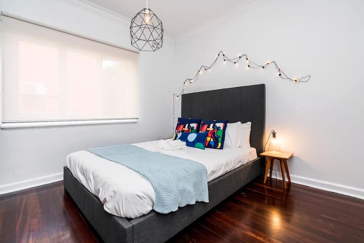 استمتع بالاسترخاء في غرفة النوم الساحرة هذه التي تتميز بالبياضات الناعمة والأجواء الجذابة والمصباح الدافئ بجانب السرير لنوم هادئ.