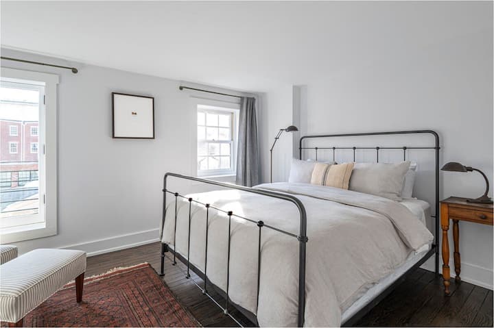 Spálňa č.2, jednotka 2 - slnečná spálňa s elegantným železným rámom postele a čistou, minimalistickou výzdobou.