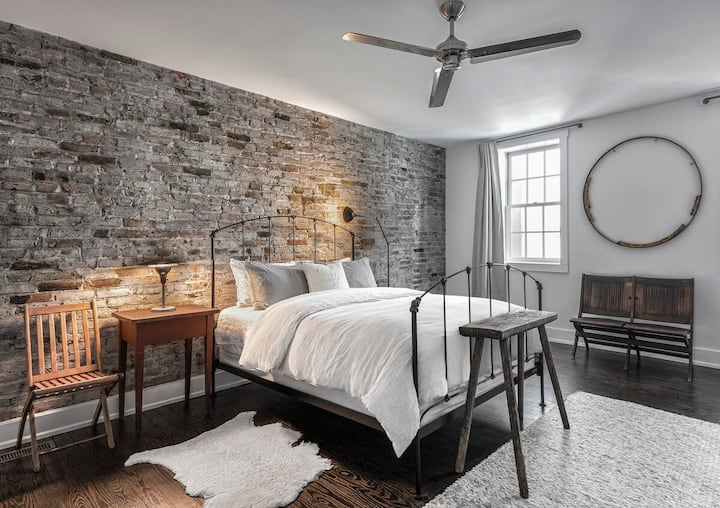 Spálňa č.1, jednotka 2 - rafinovaná spálňa miešajúca priemyselné textúry s mäkkými neutrálnymi tónmi.