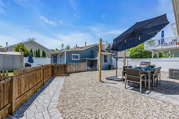 Paver patio with dining set, umbrella, and grill for alfresco dinners