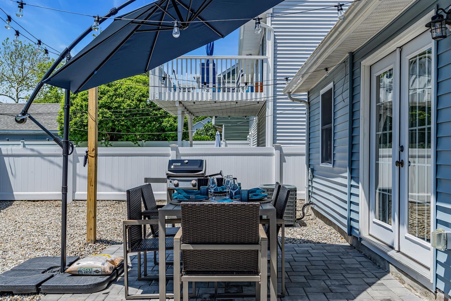 The backyard with outdoor dining, the gas grill and the paver patio